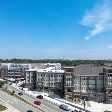 Aerial shot of The Signature at Carmel showing the building exteriors draped by a lush treeline.