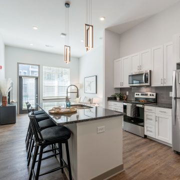 Another kitchen layout showcasing vaulted ceilings, natural light and luxurious modern fixtures.